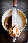 Pork rillette in a bowl with a knife