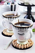 Painted coffee cups with coasters made from wooden beads