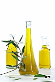 Three bottles of olive oil with an olive sprig