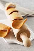 Tuiles (wafer biscuits, France) on a rolling pin