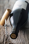 A bottle of red wine from the year 2011 with a corkscrew