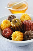 Various coloured canneles with honey