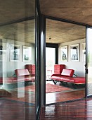 Lounge with black and white photos over red leather designer couch and red chest of drawers