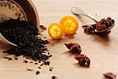 Black tea with anise stars and a kumquat on a wooden surface