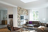 Modern seating area with zebra-skin rug and media cabinet with patchwork fronts in open-plan interior