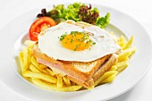 A toasted ham and cheese sandwich topped with a fried egg on a bed of chips