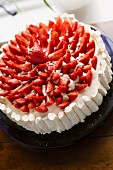 A strawberry cake with a meringue edge