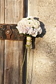 Blumenstrauss aus weissen Blumen an Vintage Schloss einer Holztür