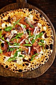 Pizza from a wood-burning oven topped with ham, rocket and Parmesan (seen above)