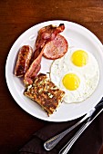 Amerikanisches Frühstück mit Spiegeleiern, Speck & Würstchen