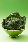 A savoy cabbage in a green bowl