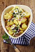 Warm potato salad with bacon and daisies