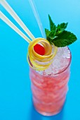 A cocktail garnished with lemon zest, mint and a cherry