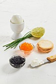 Kaviar, gekochtes Ei, Schnittlauch, Limette, Cracker und Frischkäse