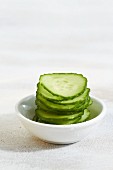 A stack of sliced cucumber in a small dish