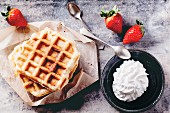 Belgian waffles served with strawberries and whipped cream