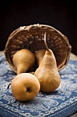 Pears and a basket on a wooden table