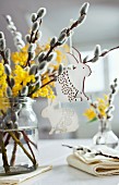 Table centrepiece of willow catkins, mimosa flowers and Easter bunny pendants