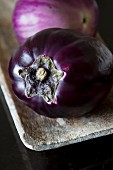 Two aubergines in a wooden dish