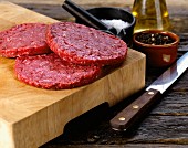 Bison burgers on a chopping board