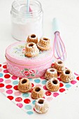 Miniature bundt cakes and pink cake tin on polka-dot napkin