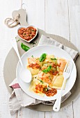 Ravioli with a minced meat sauce and basil