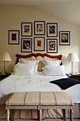 Gallery of pictures above curved headboard of antique double bed with delicate bedroom bench in foreground