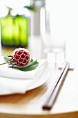 A flower on a ginkgo leaf on a place setting (Asia)
