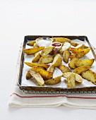 Potato wedges on a baking tray