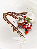 A mini cake with berries and chocolate sauce