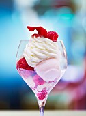 An ice cream sundae with fresh raspberries and cream