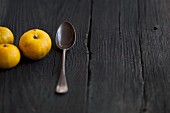 Three yuzu fruits on a wooden surface