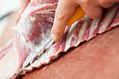 Lammfleisch von den Knochen schneiden