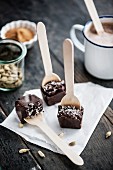 Home-made spiced drinking chocolate in solid blocks on spoons and dissolved in hot milk