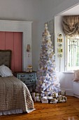 Weissgoldener, romantischer Weihnachtsbaum mit Geschenkpäckchen in antikisierendem Mädchenzimmer
