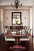 Antique table and striped upholstered chairs in elegant country-house dining area