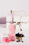 Violet vinegar in a bottle and a small glass jug