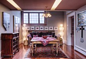 Living room with rustic wooden table, period chest of drawers and pictures on walls