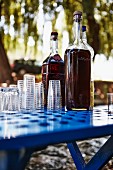 Bottles of mastika (shnapps, Croatia) with glasses on a table in a garden