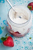 A jar of fresh organic strawberries and whipped cream