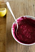 A bowl of beetroot dip with a spoon