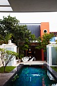 Pool und Schalensessel mit Schnurbespannung auf Terrasse vor mexikanischem Wohnhaus