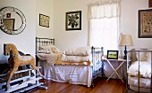 Metal beds, wooden rocking horse on old iron mechanism and collection of pictures in vintage bedroom