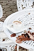 A cappuccino on a table with autumnal leaves