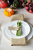 A place setting with a bunch of asparagus tied with a name tag