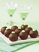 Chocolate pralines with decorated with green chocolate beans and Grasshopper cocktials in the background