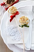 Two Christmas cake pops decorated with white cooking chocolate and nut brittle