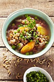 Unripe spelt grain soup with carrots and peas