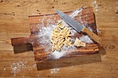 Pasta dough, cut into strips, on a chopping board