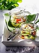 Jars of preserved courgettes with tomatoes and feta cheese